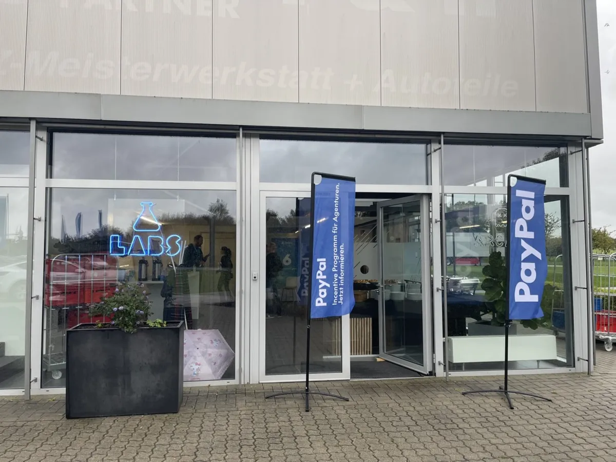 Eingang des Shopware Campus mit Labs-Leuchtschrift und PayPal-Beachflags