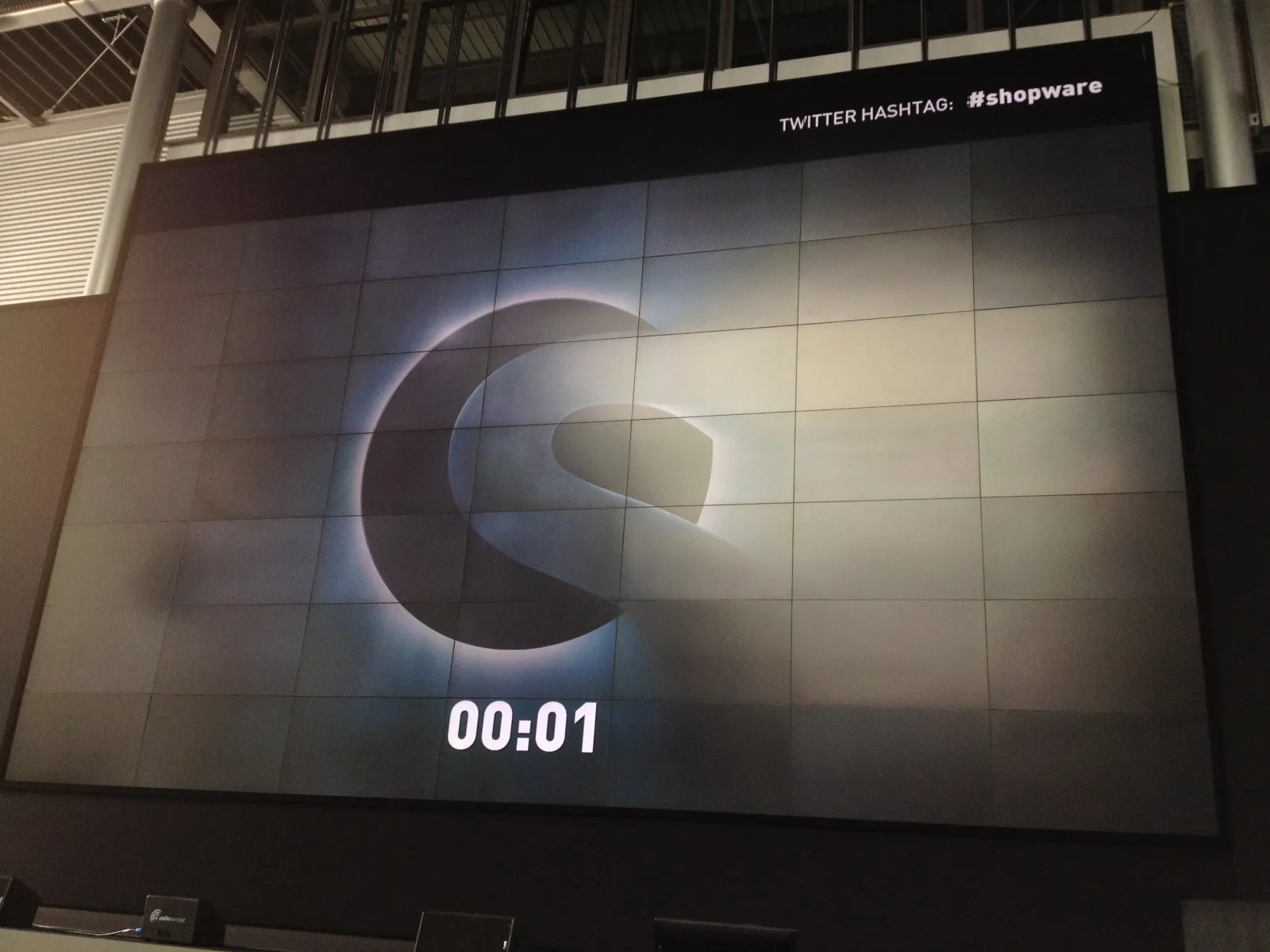 Videowand im Tobit-Atrium mit dem Shopware-Logo und dem Countdown auf 00:01 kurz vor Beginn