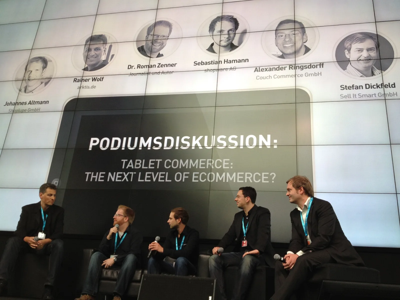 Podiumsdiskussion mit fünf Teilnehmern auf der Bühne, im Hintergrund der Titel Tablet Commerce: The next level of eCommerce?