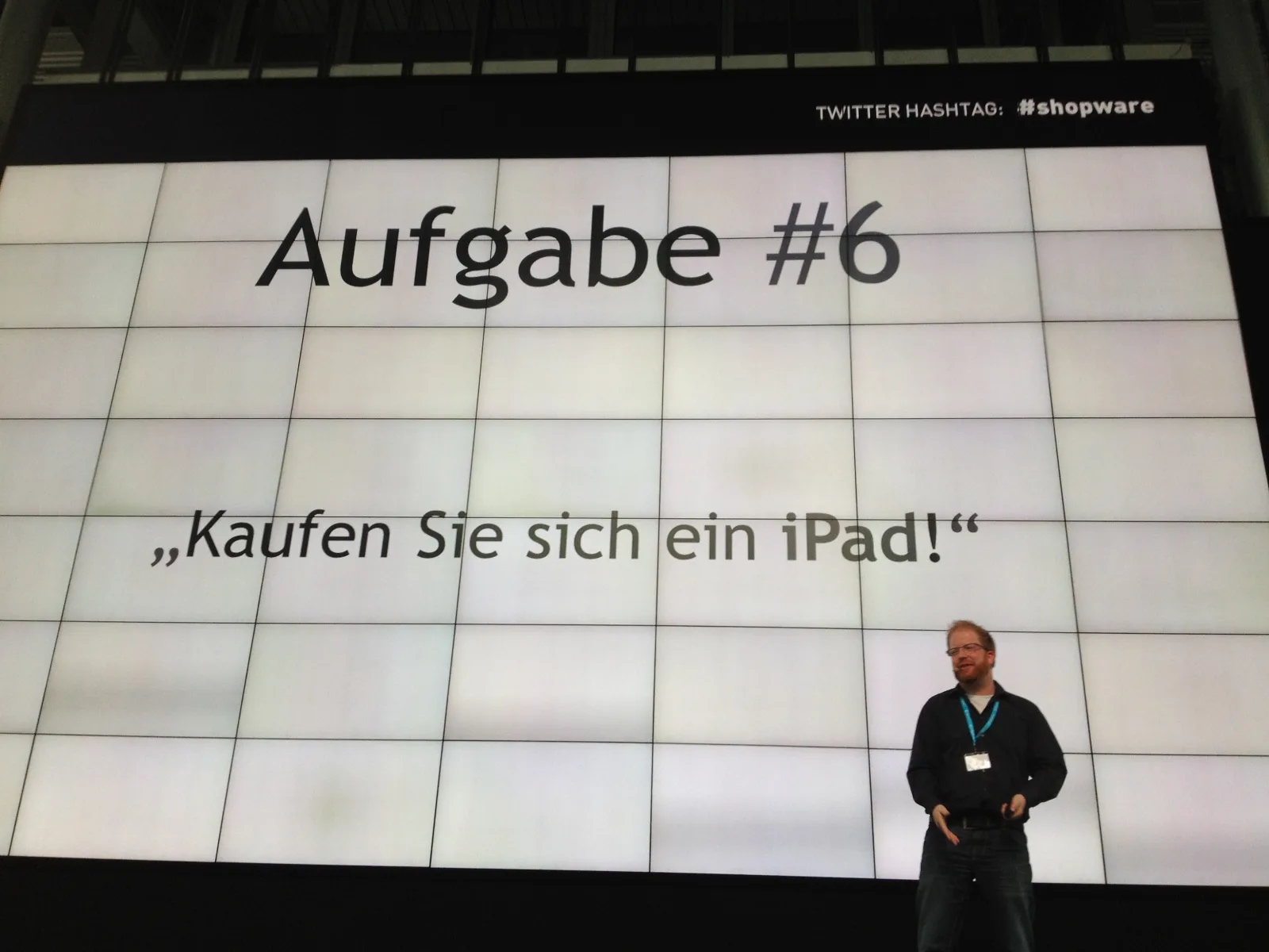 Bühnenfolie mit der Aufschrift Aufgabe #6 und dem Zitat Kaufen Sie sich ein iPad!