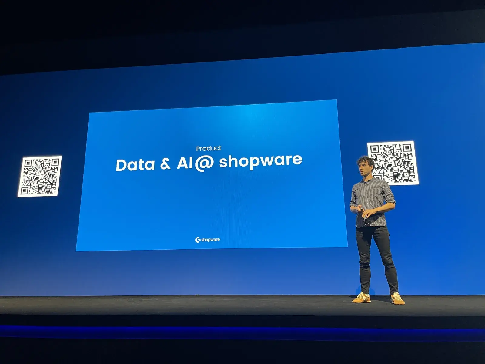 Vortrag auf der Bühne mit der Folie Product: Data und AI at shopware